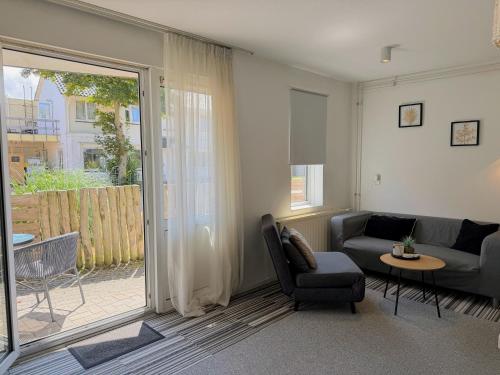a living room with a couch and a chair at Texelheerlijk 10 in De Koog
