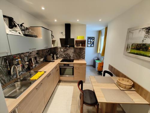 a kitchen with a sink and a table and a counter at Kurhotel Wiedenmann in Bad Wörishofen