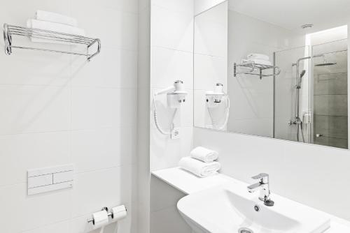 a white bathroom with a sink and a mirror at B&B HOTEL A Coruña Aeropuerto in Culleredo
