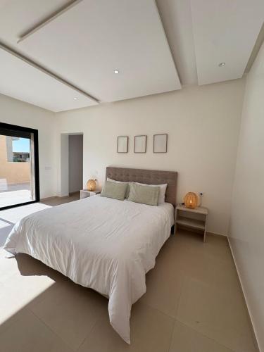 a large white bedroom with a large white bed at Villa Émeraude in Marrakesh