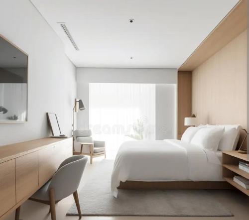 a white bedroom with a large bed and a chair at The corbett story in Rāmnagar