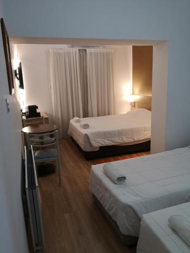 ein Hotelzimmer mit zwei Betten und einem Tisch in der Unterkunft Ekali Hotel in Kakopetria