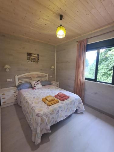 a bedroom with a bed with towels on it at O LAR DO SIL - Ribeira Sacra in Villar de Cerreda