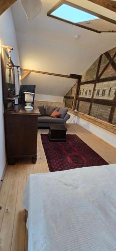 a bedroom with a bed and a couch in a room at Altes Saale Fährhaus in Naumburg