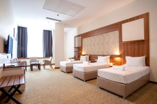a hotel room with two beds and a couch at Kule Hotel & Spa in Gaziantep