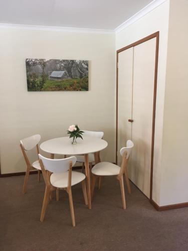 a dining room with a white table and chairs at Acorn Lodge in Bright