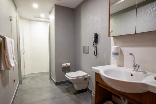 a bathroom with a sink and a toilet and a phone at Kule Hotel & Spa in Gaziantep