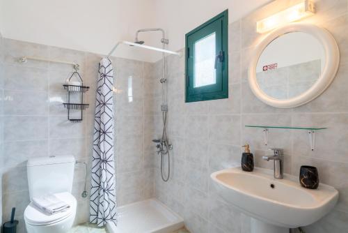 a bathroom with a sink toilet and a mirror at Maria Anastasia Studios in Trapezaki