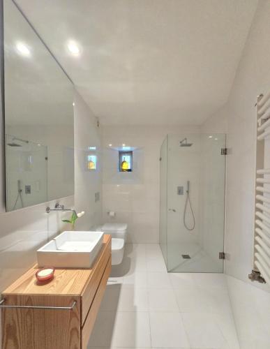 a white bathroom with a sink and a shower at Quinta de Chousas - Braga - Agroturismo in Braga
