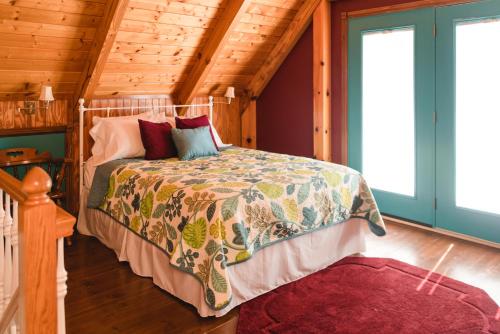 ein Schlafzimmer mit einem Bett in einer Holzhütte in der Unterkunft The Lake House A Hidden Gem Sleeps 4 in Columbia