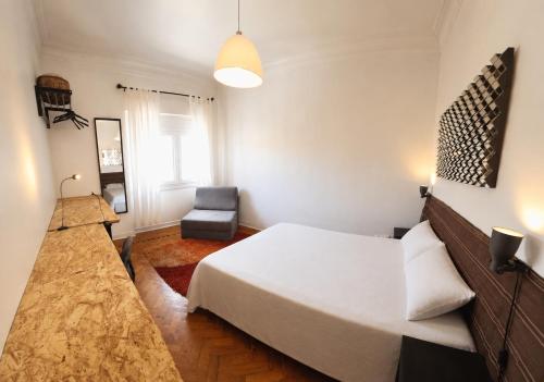 a bedroom with a white bed and a chair at Parque das Nações Room in Lisbon