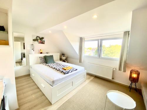 a bedroom with a white bed and a window at Ruhige Gästezimmer in Bonn mit Gemeinschaftsbad & Küche in Bonn