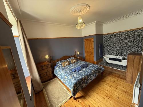 a bedroom with a bed and a bath tub at Stunning Hideaway on Loch Goil in Carrick