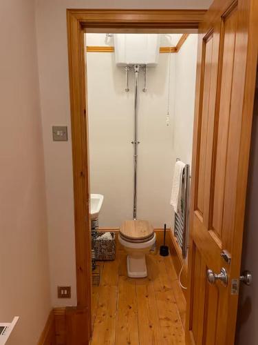 a small bathroom with a toilet and a sink at Stunning Hideaway on Loch Goil in Carrick