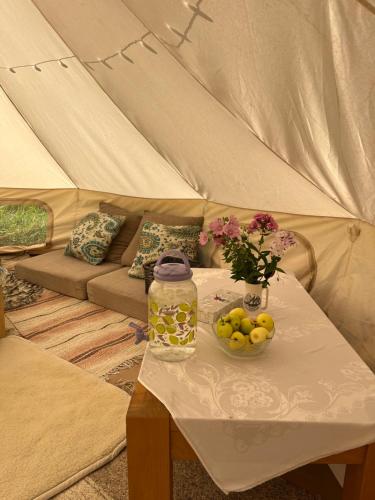 a tent with a table with a bowl of fruit at Vallimäe Glamping Otepää in Mägestiku