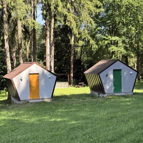 two small houses sitting in a field of grass at Ďurkovec Centrum in Spišské Tomášovce
