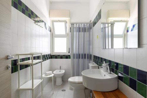 a white bathroom with a sink and a toilet at Villa Collina in Giardini Naxos