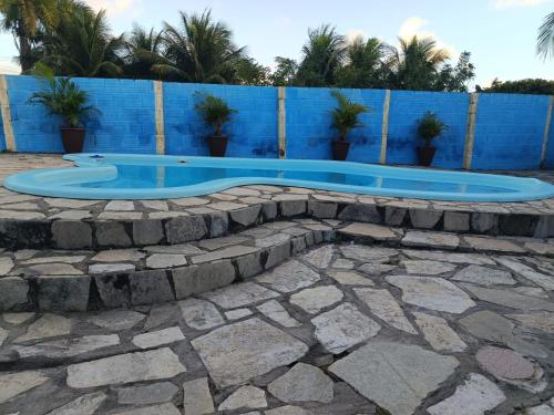 a swimming pool in the middle of a stone patio at Recanto Das Marés in Jacumã