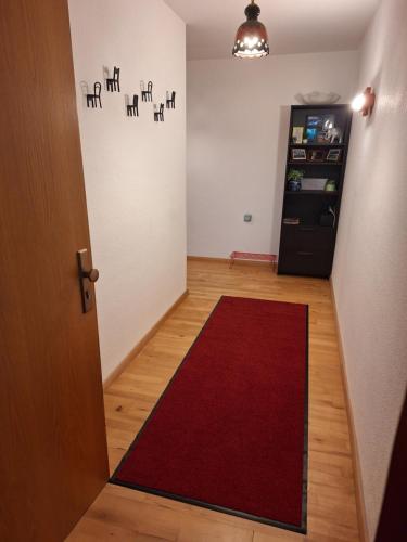 a room with a red rug on the floor and a door at Forstoase Deister in Bredenbeck