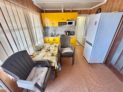a small kitchen with a table and a white refrigerator at домик у самого моря in Odesa