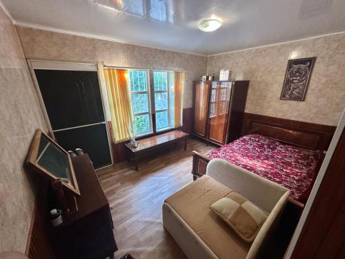 a bedroom with a bed and a couch and windows at домик у самого моря in Odesa