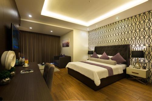 a bedroom with a bed and a desk in a room at Lenox Hotel in Dagupan
