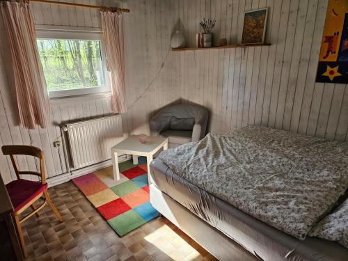 a bedroom with a bed and a table and a chair at Unser Hasenstall in Wietzendorf
