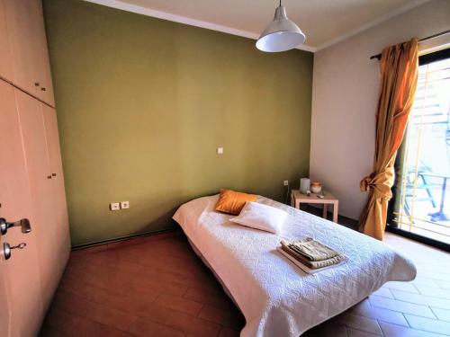 a bedroom with a bed in a room with a window at House M A R Y in Pefkali