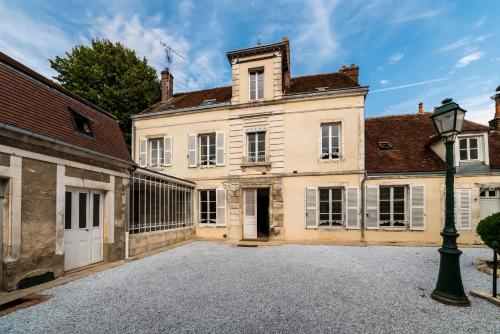 an exterior view of a large house with a driveway at La Villa Ribière in Auxerre
