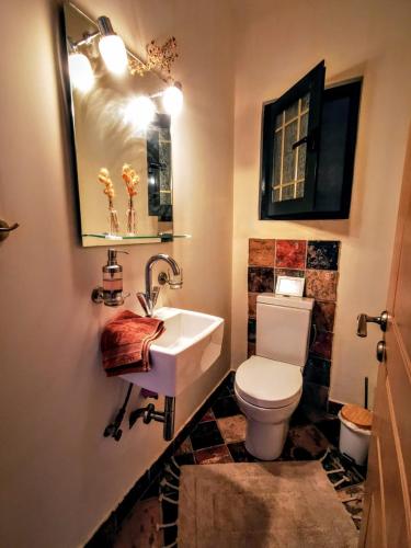 a bathroom with a white toilet and a sink at House M A R Y in Pefkali