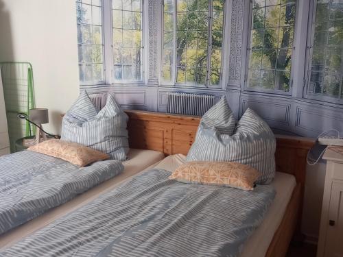 two beds sitting in a room with windows at Villa Sommersted Tanja Blixen in Sommersted