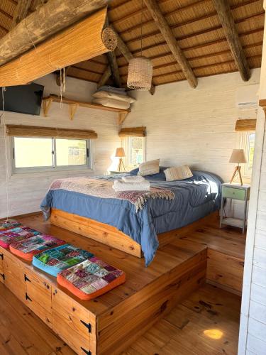 a bedroom with a bed in a log cabin at Casa Papaya in Punta Del Diablo