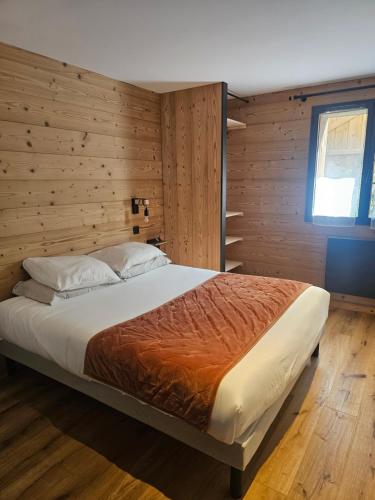 a bedroom with a bed with a wooden wall at Appartement bas de chalet in Font-Romeu-Odeillo-Via