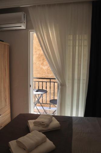 a bedroom with a bed and a window with a balcony at Dany's studio central xanthi in Xanthi