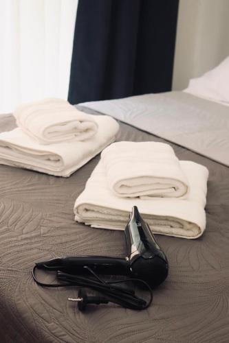 a pair of towels and a phone on a bed at Dany's studio central xanthi in Xanthi