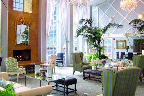 a lobby with chairs and tables and a fireplace at The Portofino Hotel & Marina, a Noble House Hotel in Redondo Beach