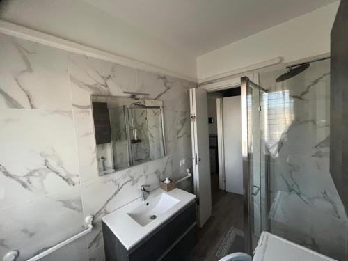 a white bathroom with a sink and a shower at bilocale con NETFLIX INCLUSO in Lodi