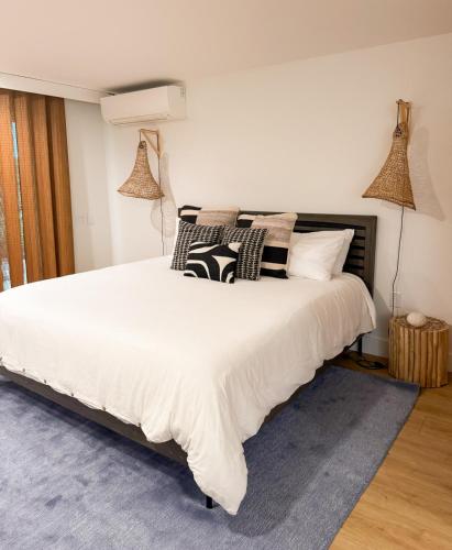 a bedroom with a large white bed with pillows at Kona Hang Loose Studio in Kailua-Kona