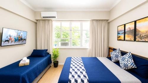 a bedroom with two beds and a couch at Flat Premium a 500m do aeroporto Santos Dumont & Consulados in Rio de Janeiro
