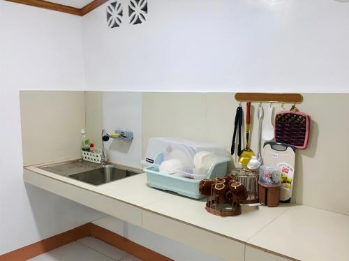a kitchen counter top with a sink and a counter top at Queen's Guest House in El Nido