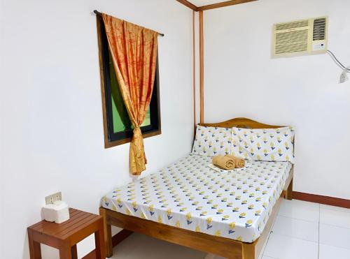 a small bed in a room with a window at Queen's Guest House in El Nido