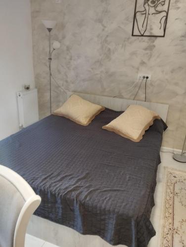 a bed with two pillows on it in a room at Solid House - Sunrise Apartment in Mamaia