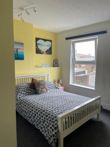 a bedroom with a bed and a window at Henry's On The Prom in Great Yarmouth