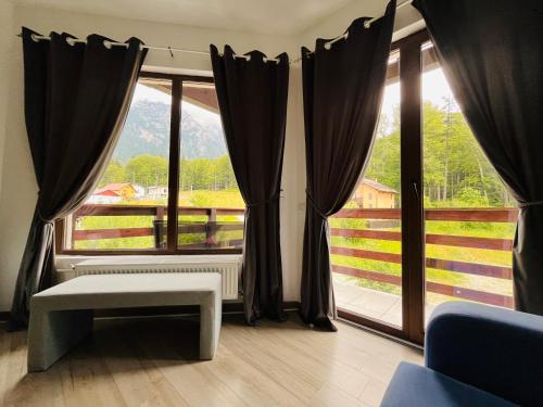 a living room with a large window with a view at Vila Mama Jana in Buşteni