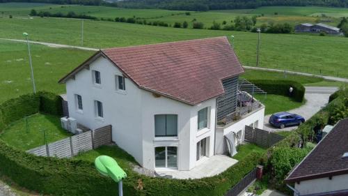 a white house with a brown roof at L'Aquarium Attigneville in Attignéville
