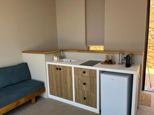 a small kitchen with a sink and a blue chair at Alos Suites in Verga Kalamata