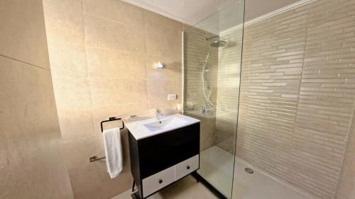 a bathroom with a sink and a glass shower at The Nile Dahabiya Lodge in Luxor