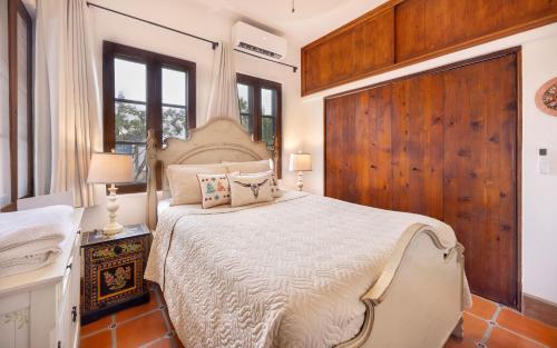 a bedroom with a large bed with a wooden wall at Casa Perla de Todos Santos in Todos Santos