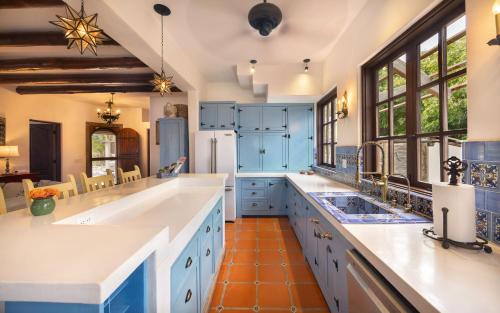 a large kitchen with white counters and blue cabinets at Casa Perla de Todos Santos in Todos Santos