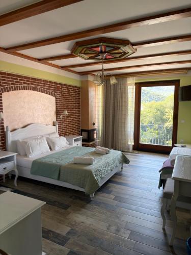 a bedroom with a large bed and a large window at Neromylos in Nikísiani